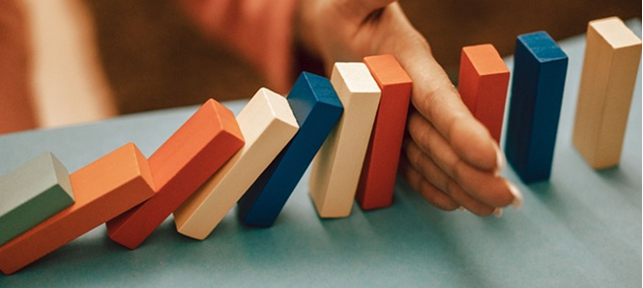 Dominopalikat, jotka ovat kaatumassa. Kuvaa tapahtumia, joilla on taipumus ketjuuntua