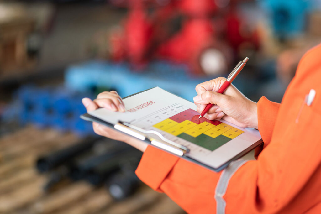 Työntekjä täyttää kädessään olevaa riskimatriisia